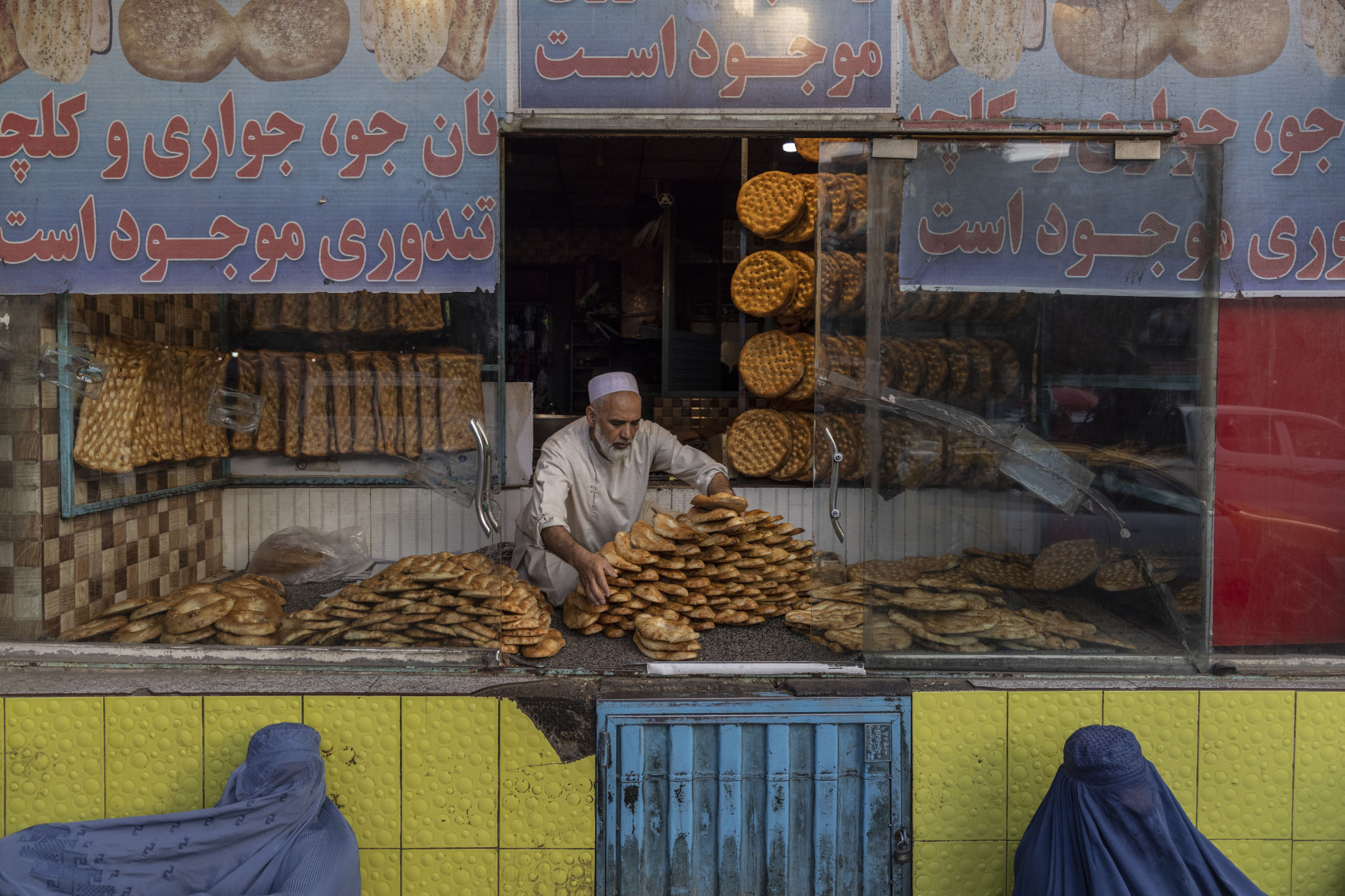 Women begging for alms outside a bakery in Kabul